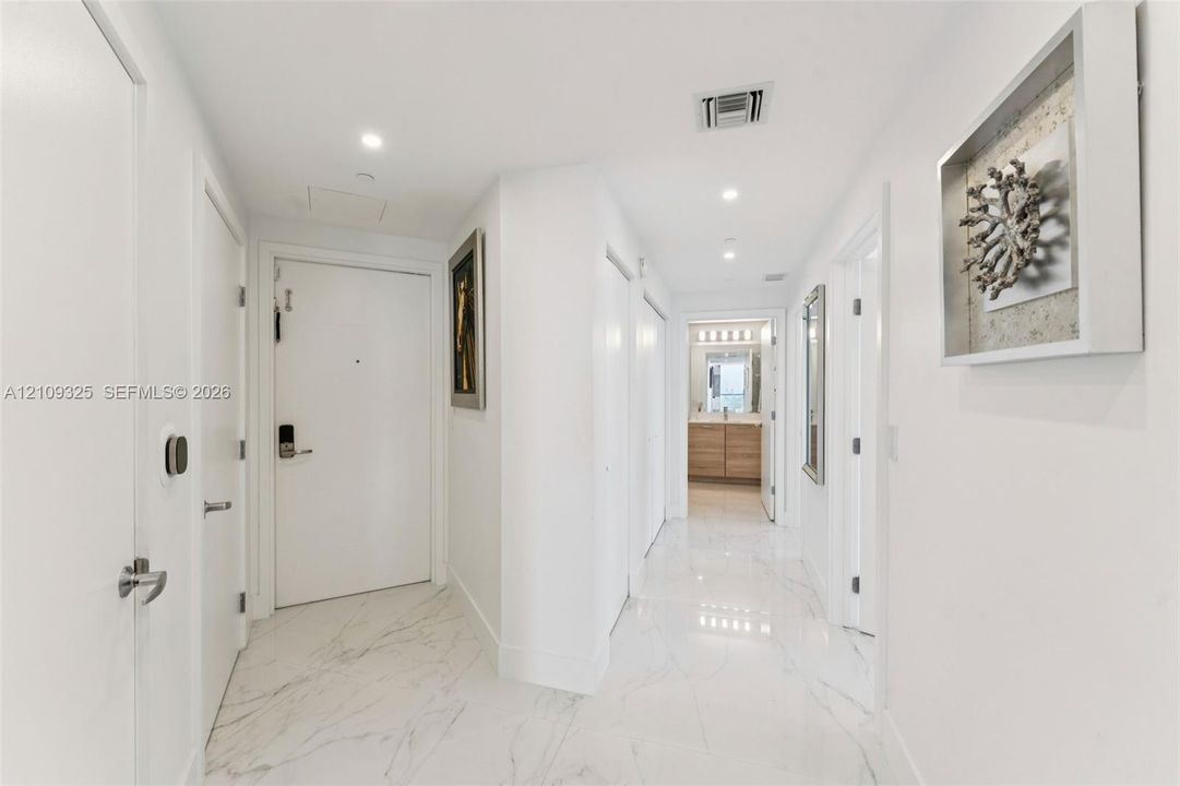 Entryway featuring polished stone-finish flooring, recessed lighting, and crisp white interior doors