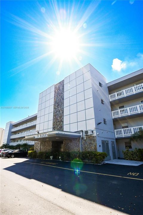 Multi-story exterior featuring panelized facade, natural stone cladding, and balconies