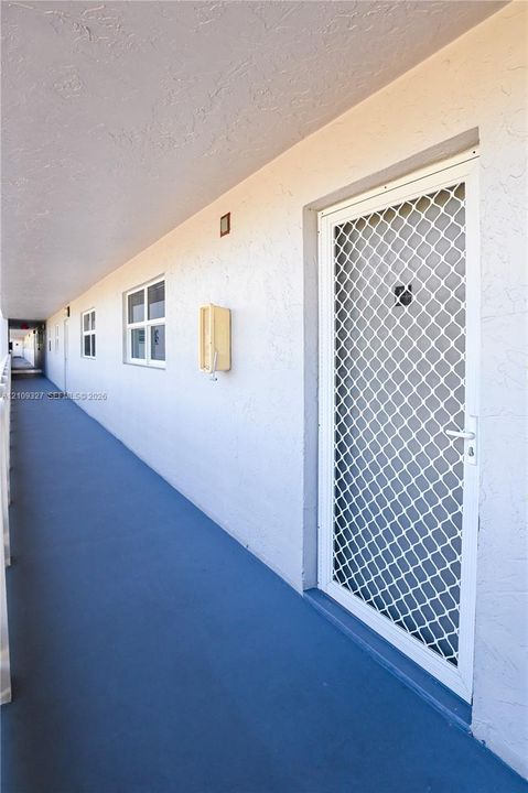 Exterior entry featuring a white metal security storm door