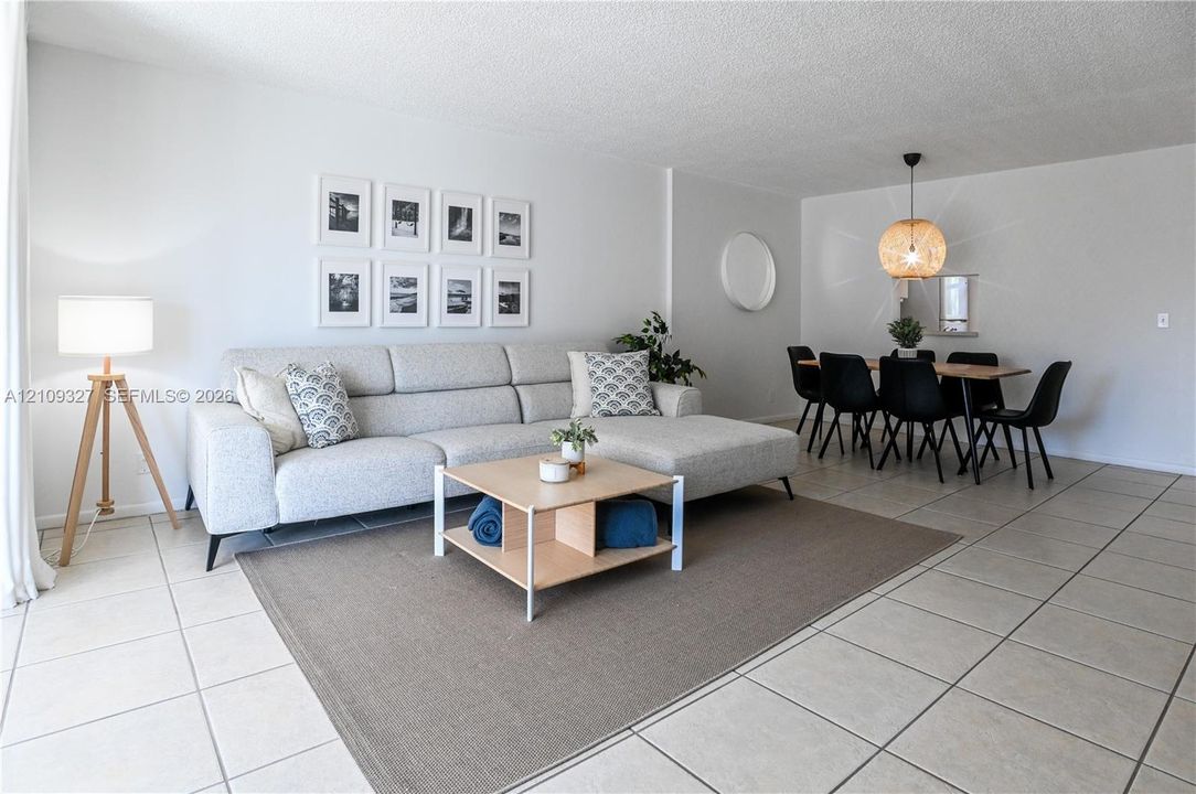 Neutral-toned ceramic tile flooring, rounded wall mirror, and woven pendant light fixture