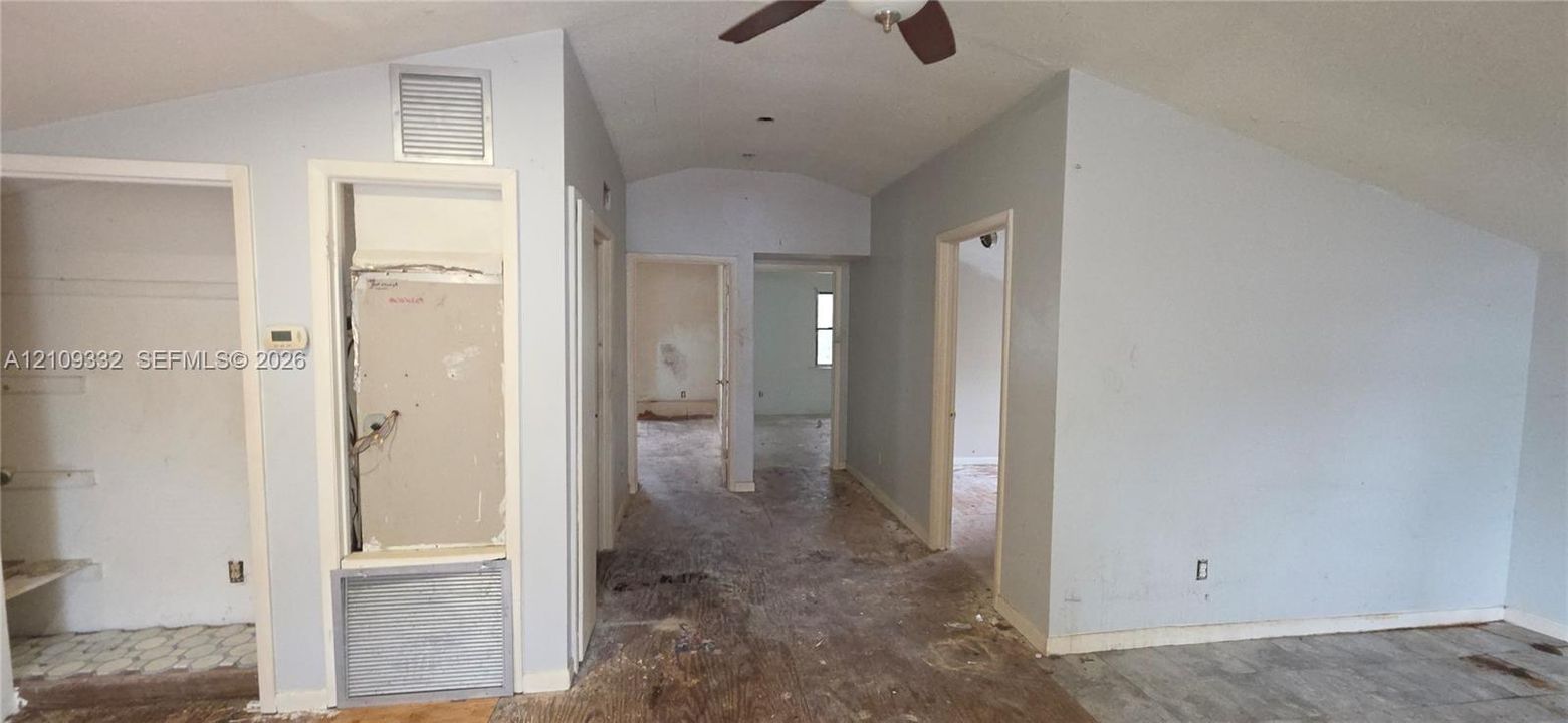 Vaulted ceiling featuring a central ceiling fan