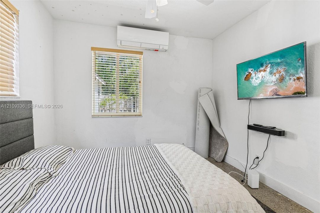 Wall-mounted ductless air conditioning unit, ceiling fan, and horizontal window blinds