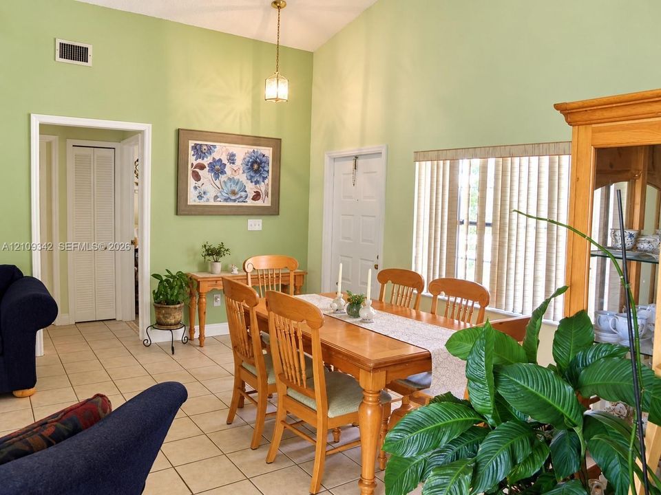Vaulted ceilings, tile flooring, and vertical window blinds