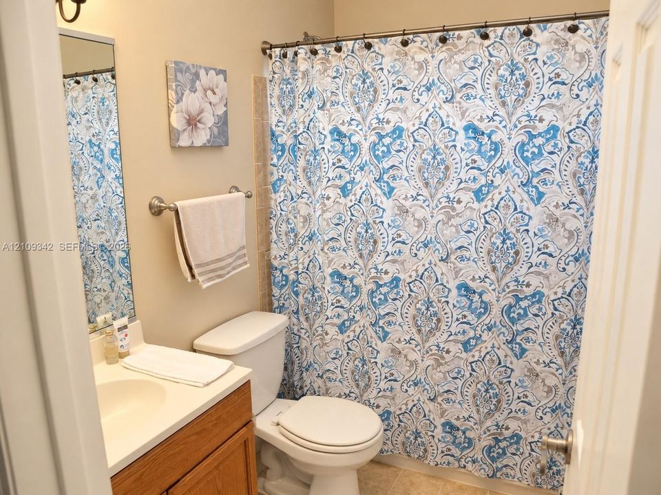 2nd Bathroom featuring a vanity with integrated sink, wood-finish cabinetry, a wall-mounted mirror, and a tub-shower combination