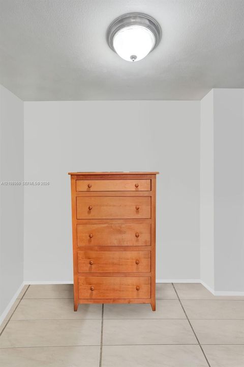 Neutral wall finishes, flush-mount circular ceiling lighting, and tile flooring