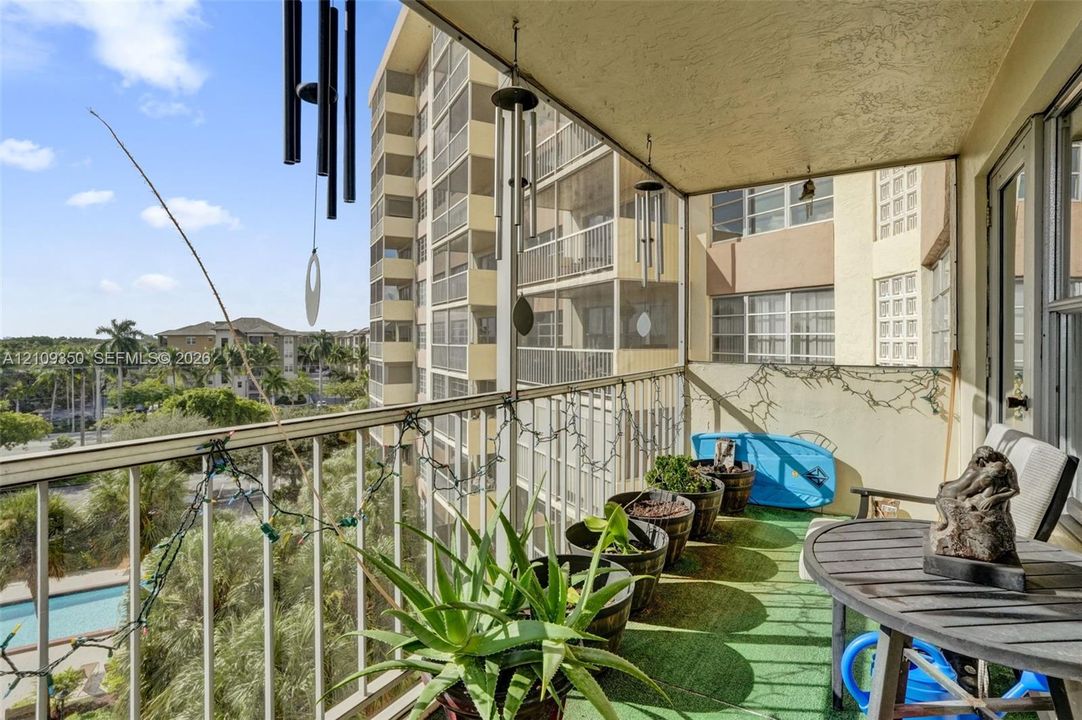 Covered balcony featuring metal railings, textured ceiling finish, and an exterior entrance