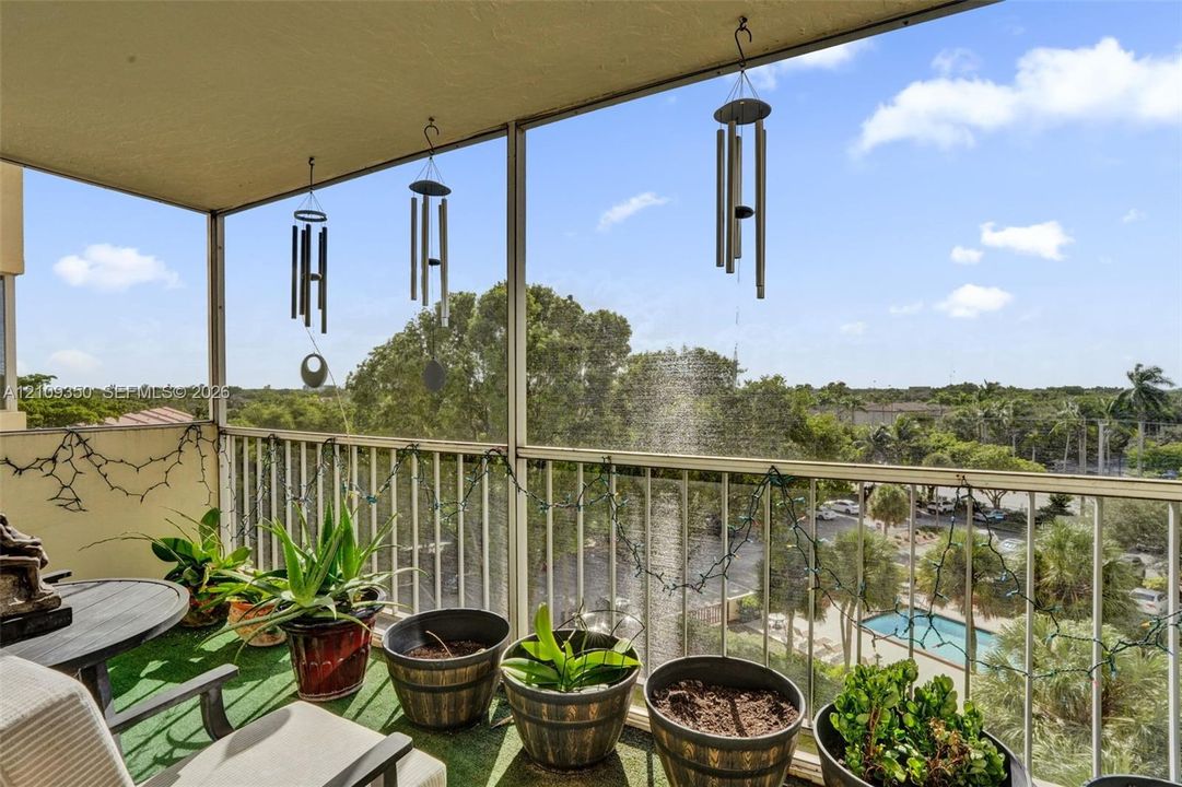 Screened balcony featuring metal railings and concrete flooring