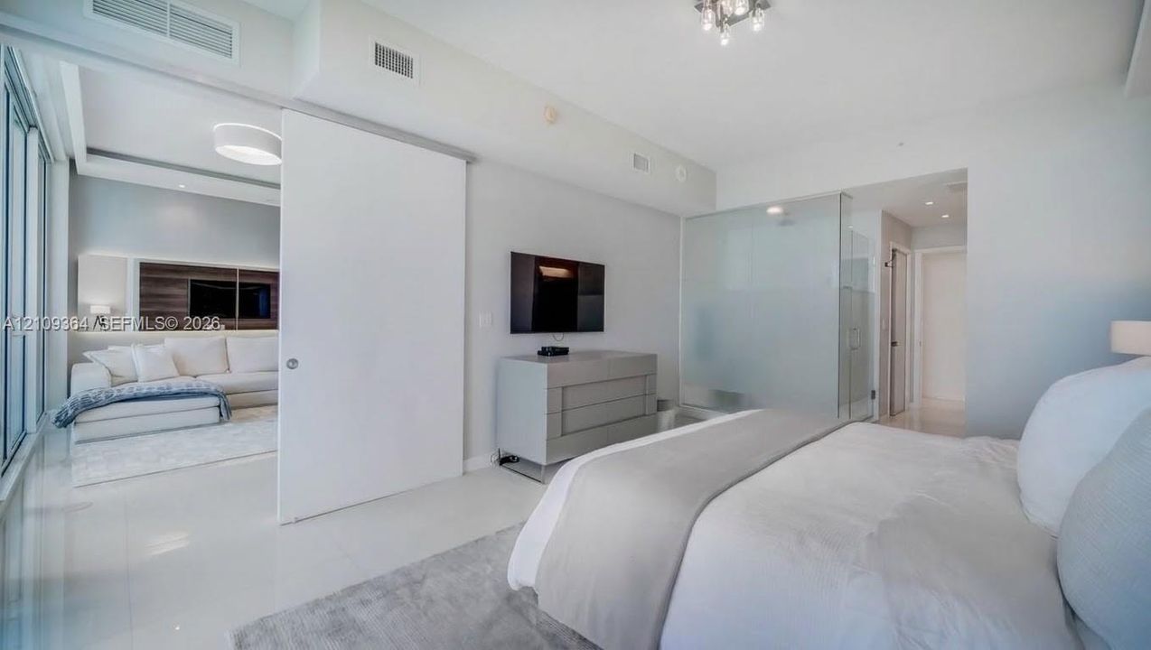 High-gloss flooring, sliding floor-to-ceiling door, and frosted glass wall partitions.