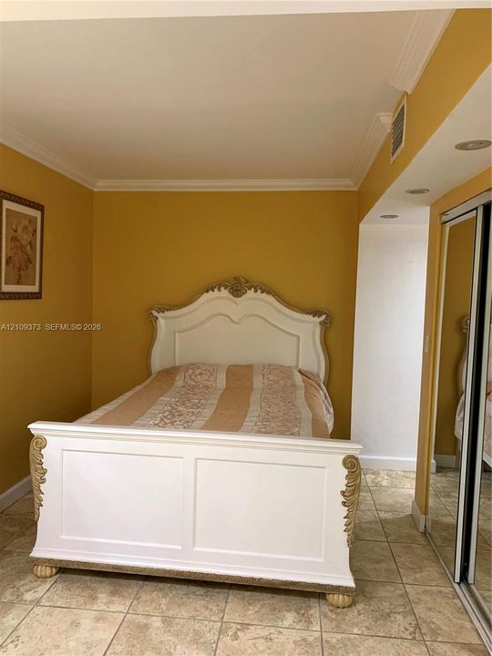 Room featuring neutral-toned tile flooring, recessed ceiling lighting, and a floor-to-ceiling mirrored closet door