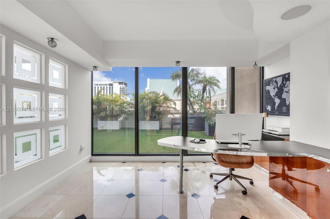Floor-to-ceiling windows, stone tile flooring with decorative inlay, built-in high-gloss cabinetry, recessed ceiling lighting, and custom geometric glass wall panels