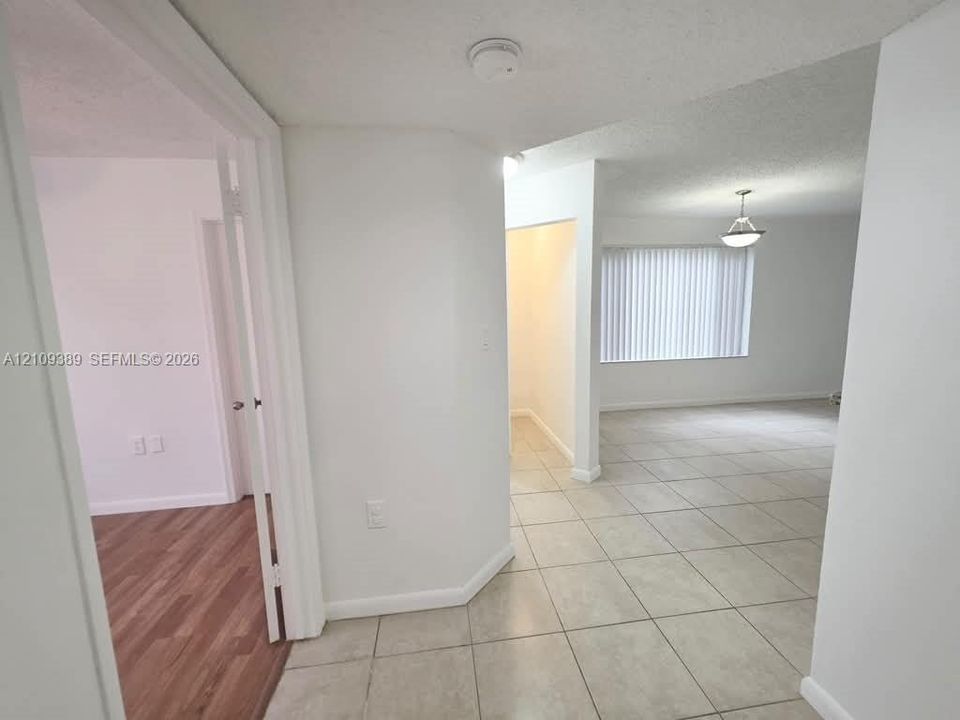 Room featuring wood-finish flooring, a ceiling fan, and a window with horizontal blinds, complemented by a louvered bi-fold closet door