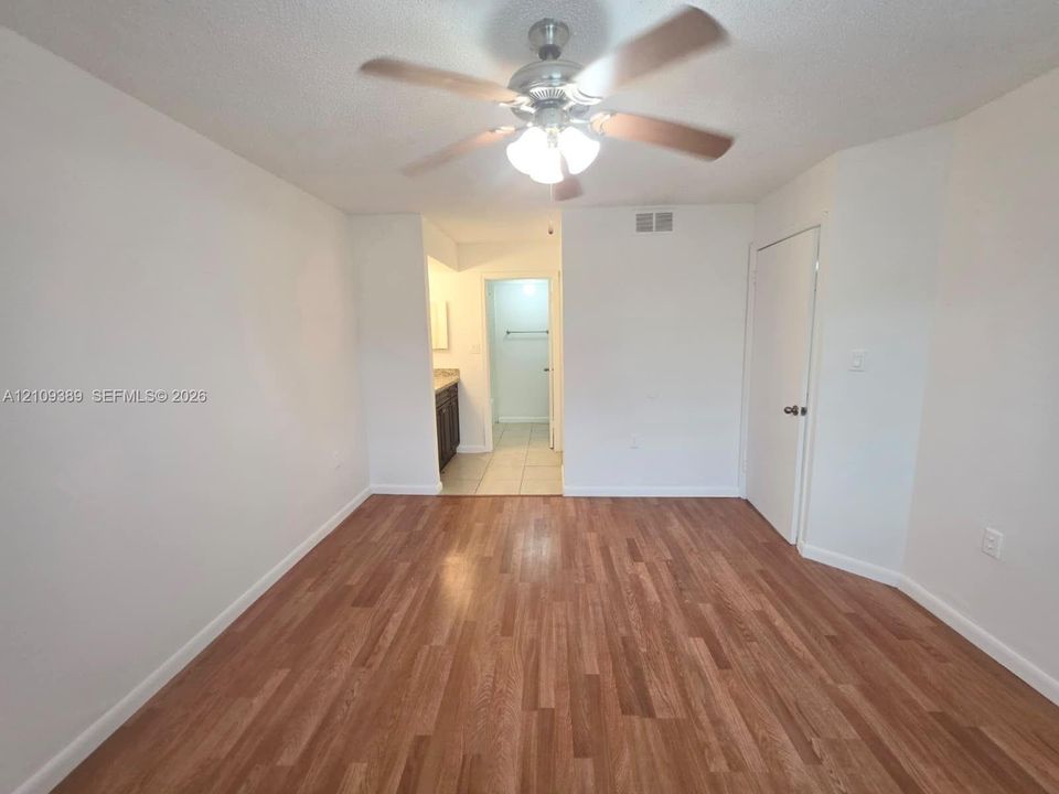 Neutral tile flooring, ceiling fan with integrated lighting, dual pendant light fixtures, and louvered closet doors