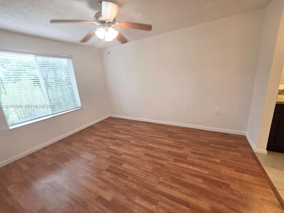 Neutral wall tones, ceramic tile flooring, and dual closets featuring white louvered doors