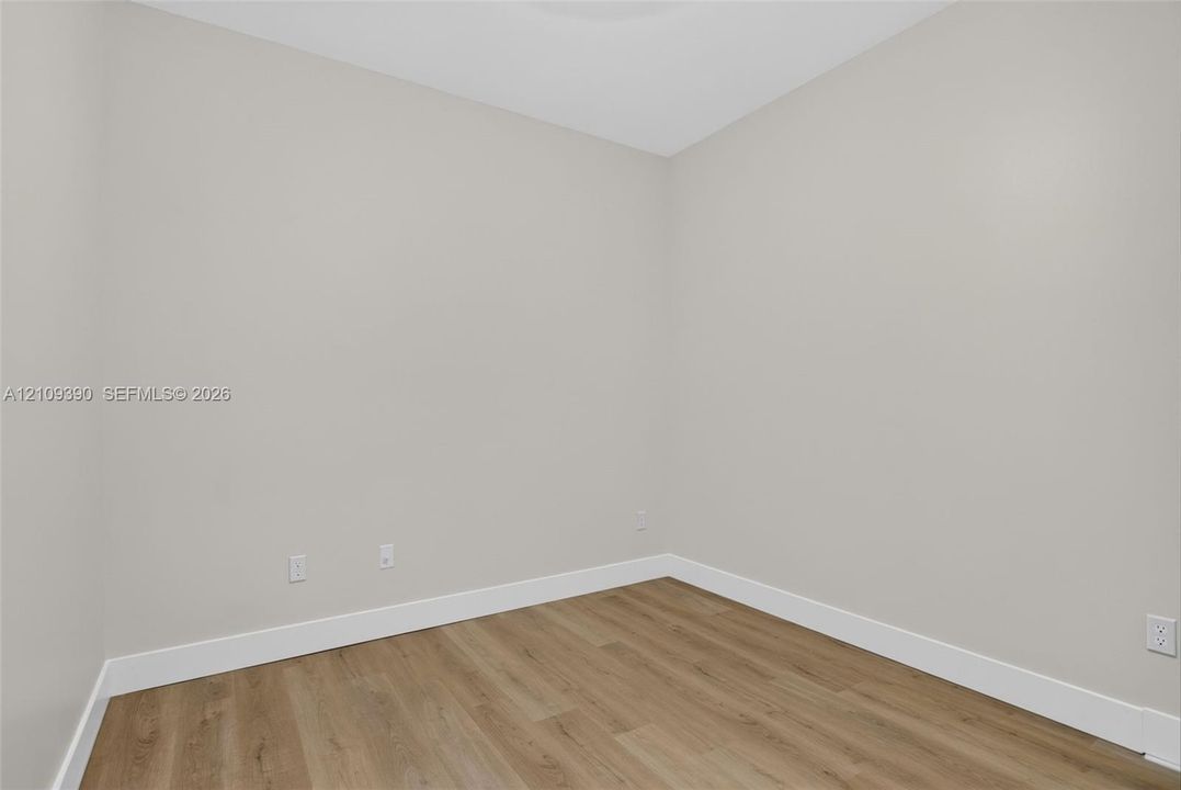 Neutral-toned wall finish, wood-finish flooring, and crisp white trim