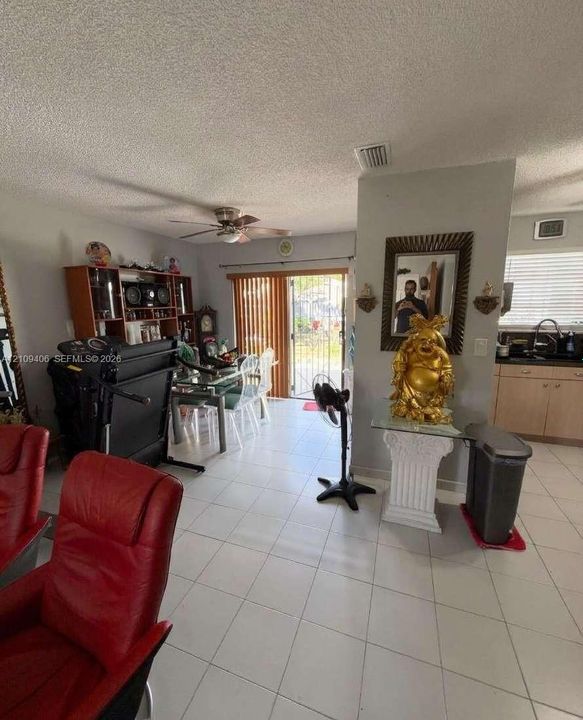 Ceramic tile flooring, ceiling-mounted fan, and glass sliding door access to exterior space