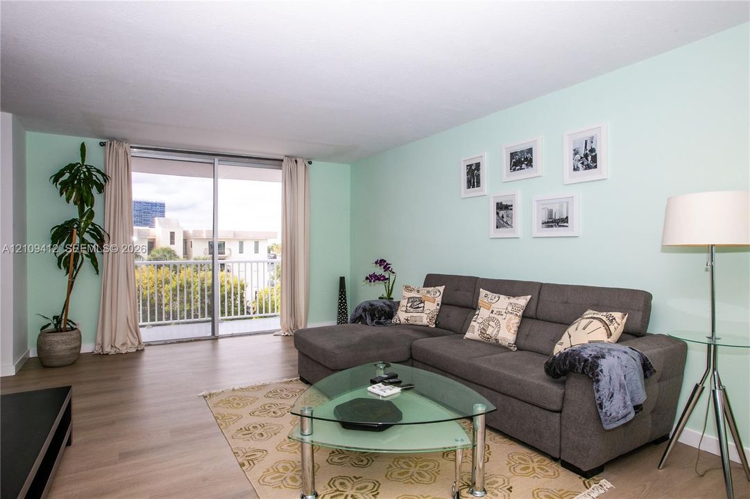 Living area featuring wood-finish flooring and sliding glass doors with access to an exterior balcony