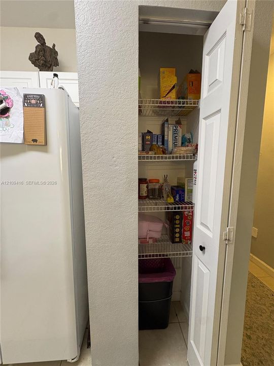 Pantry featuring a six-panel door and white coated-wire shelving