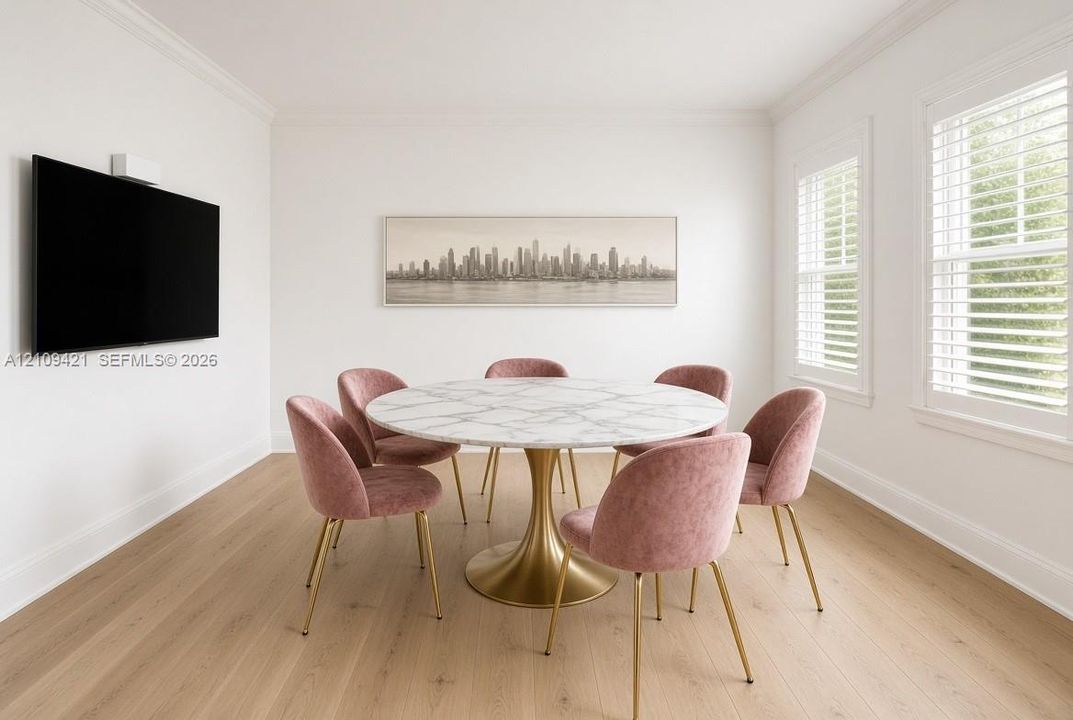 Bright room featuring wood-finish flooring, dual windows with plantation shutters, and crown molding