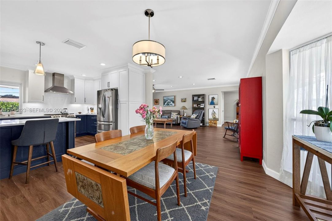 Kitchen featuring two-tone cabinetry, stainless steel appliances, a center island, and wood-finish flooring