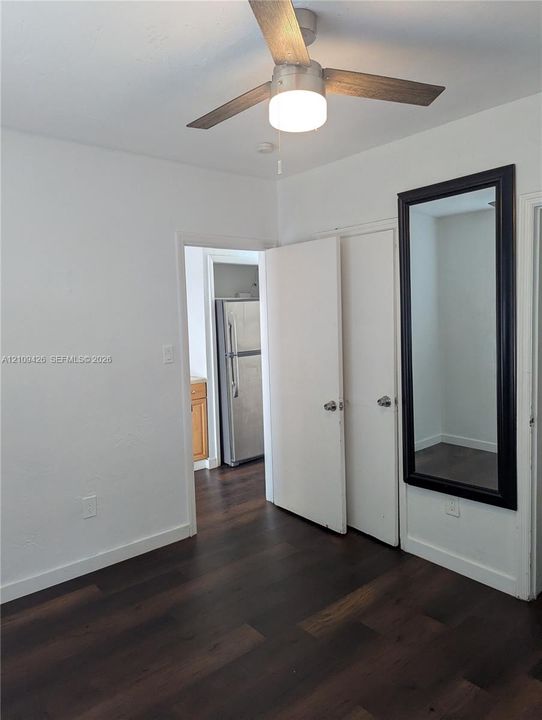 Wood-finish flooring, ceiling fan with integrated lighting, and dual hinged doors