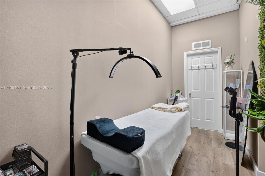 Enclosed room featuring neutral-toned walls, wood-finish flooring, and a recessed ceiling light panel