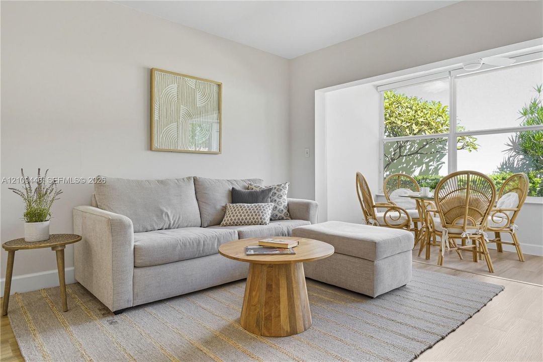 Neutral-toned interior space featuring light-colored wood-finish flooring, a large expansive window, and a recessed alcove