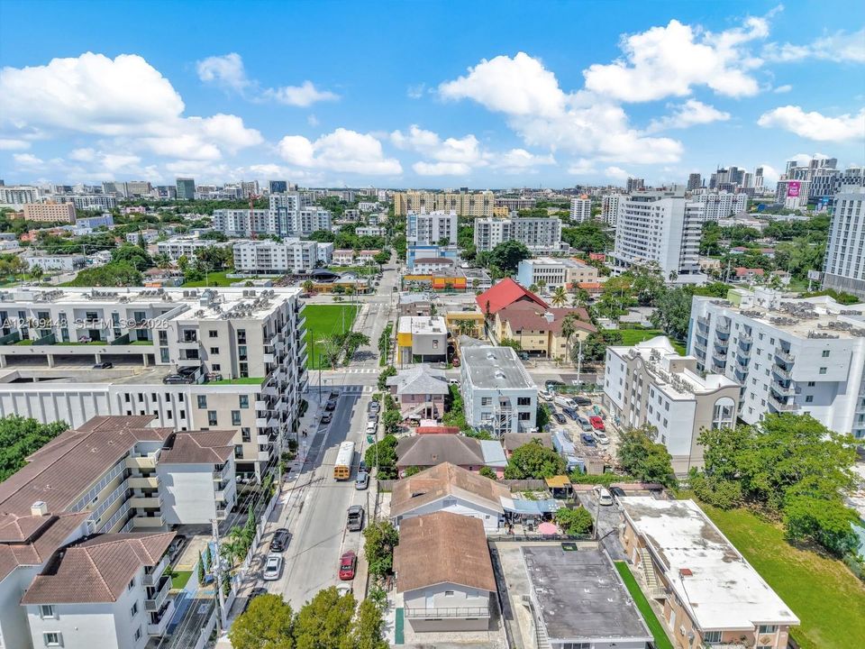 Aerial perspective of a dense urban environment featuring multi-story residential buildings, paved street infrastructure, and varied roofing materials