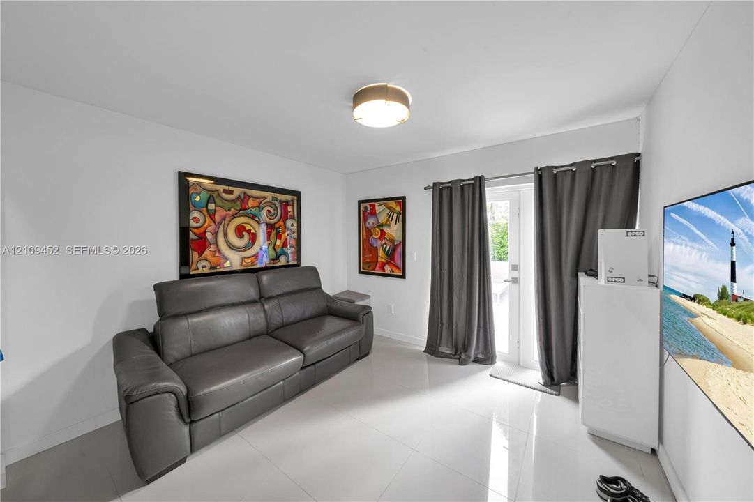Polished tile flooring, neutral wall finishes, flush-mount ceiling lighting, and a glass-paneled exterior door