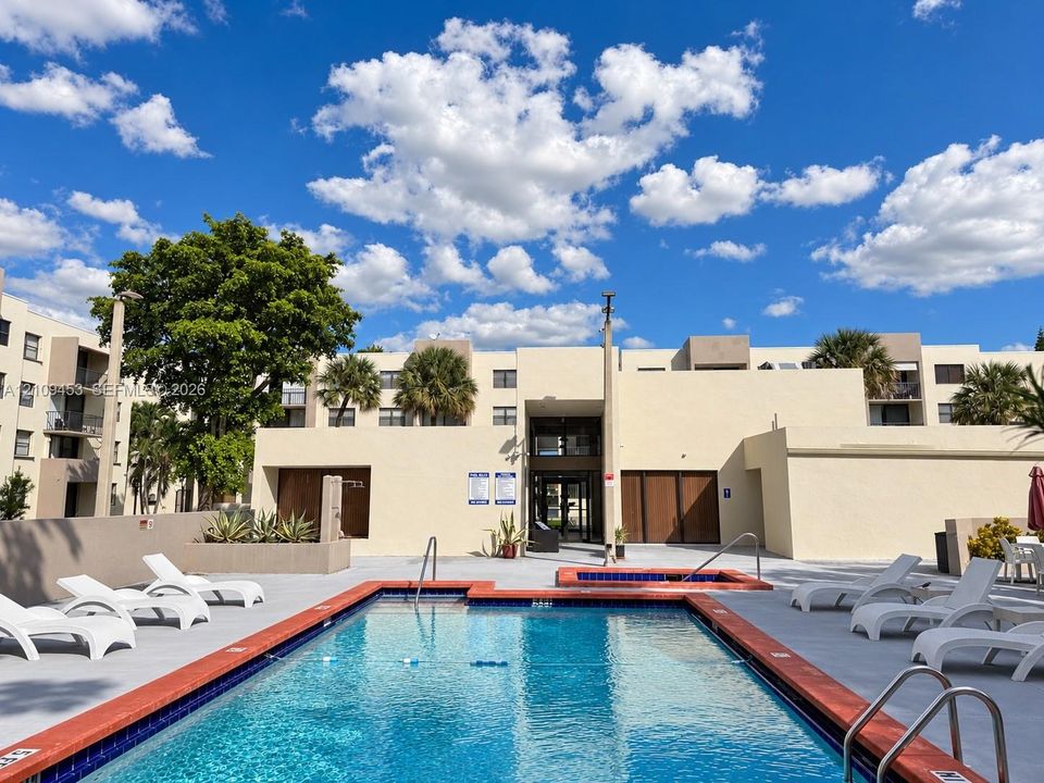 Swimming pool with tiled coping, attached spa, and surrounding concrete deck