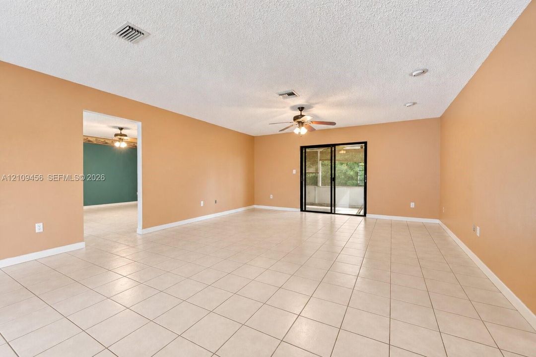 Open-concept space featuring tile flooring, recessed lighting, a ceiling fan, and sliding glass doors