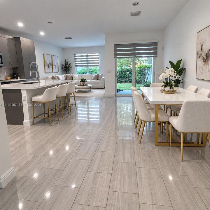 Kitchen featuring flat-panel cabinetry, a central island with a stone-surface countertop, stainless steel appliances, and large-format tile flooring