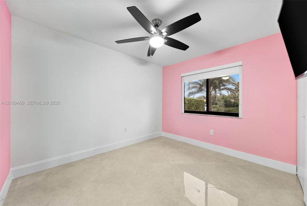 Bedroom with accent wall and ceiling fan