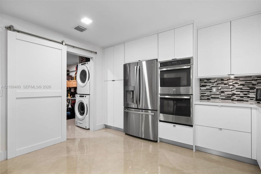 Stainless refrigerator and stacked wall ovens