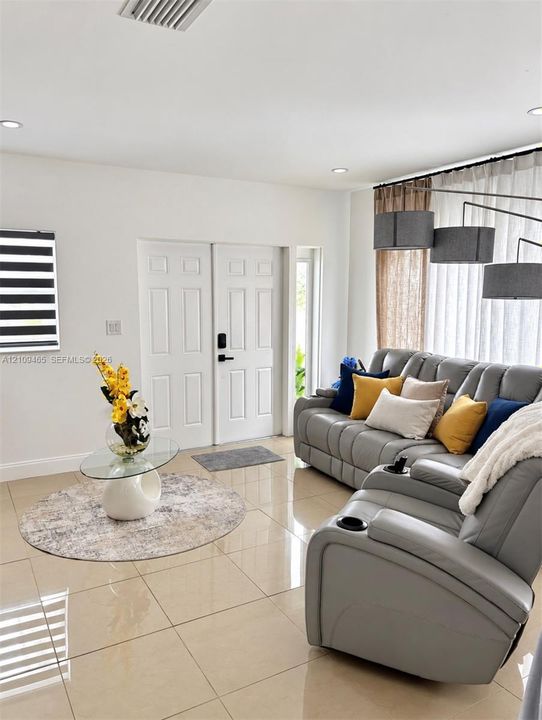 Large-format neutral tile flooring, recessed ceiling lighting, and crisp white interior walls