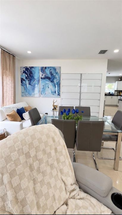 Interior space featuring neutral polished floor tiles, recessed ceiling lighting, and a large multi-panel glass-front wall cabinet