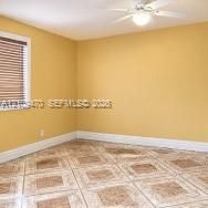 Room featuring ceramic tile flooring, horizontal window blinds, and a central ceiling fan with an integrated light fixture
