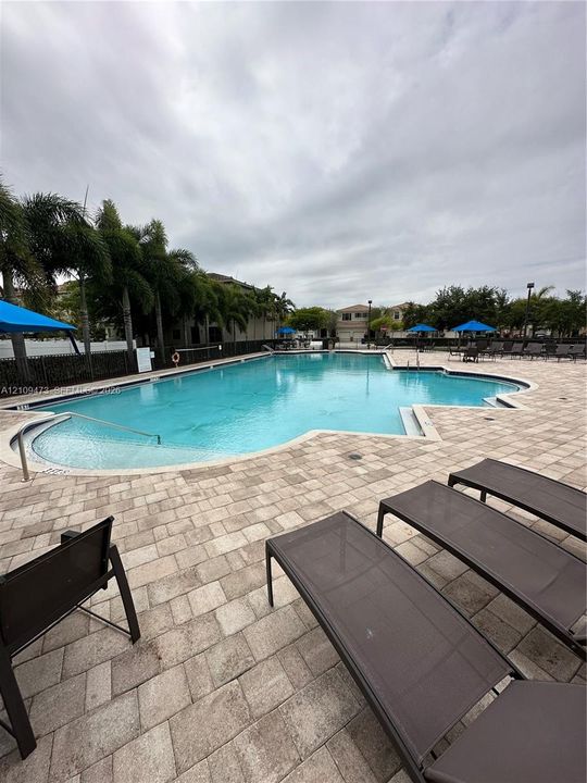 Swimming pool featuring a stone-paver deck and built-in entry steps
