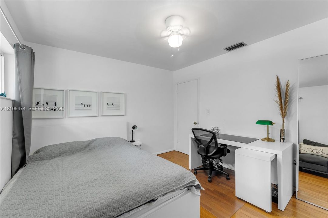 Room featuring wood-finish flooring and a multi-globe ceiling light fixture