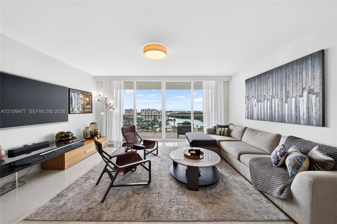 Floor-to-ceiling windows, wood-finish flooring, accent wall, and flush-mount ceiling lighting
