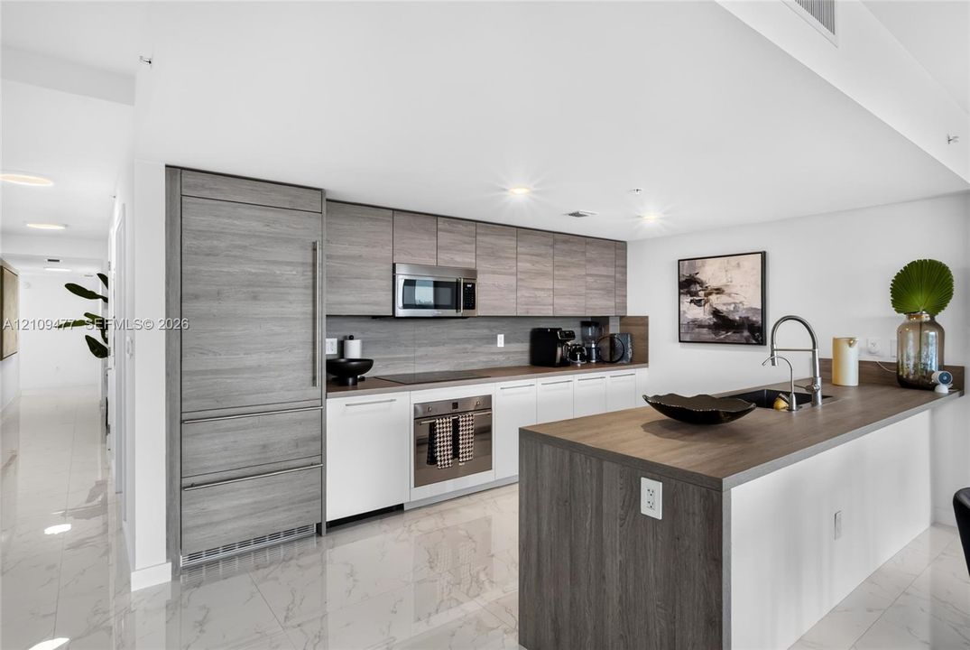 Private balcony featuring glass railings and tile flooring, offering expansive water and cityscape scenery