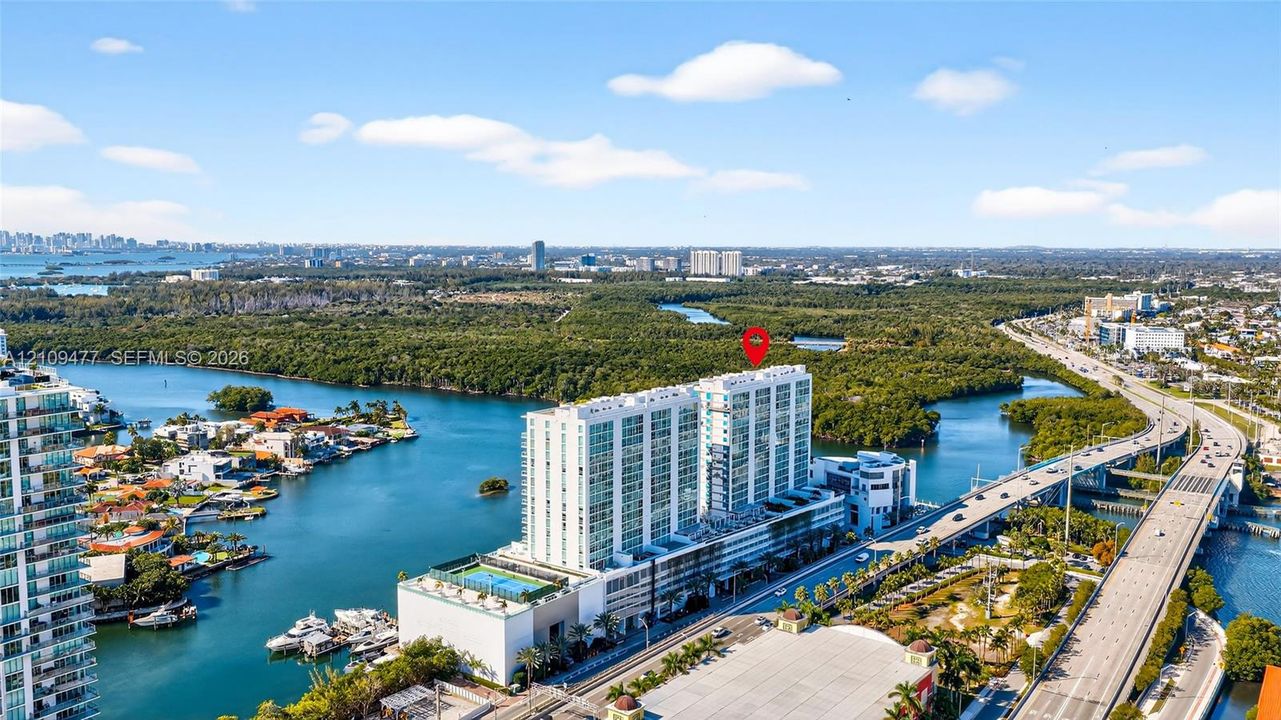 Aerial perspective of high-rise building situated on a waterway with prominent proximity to the coastline