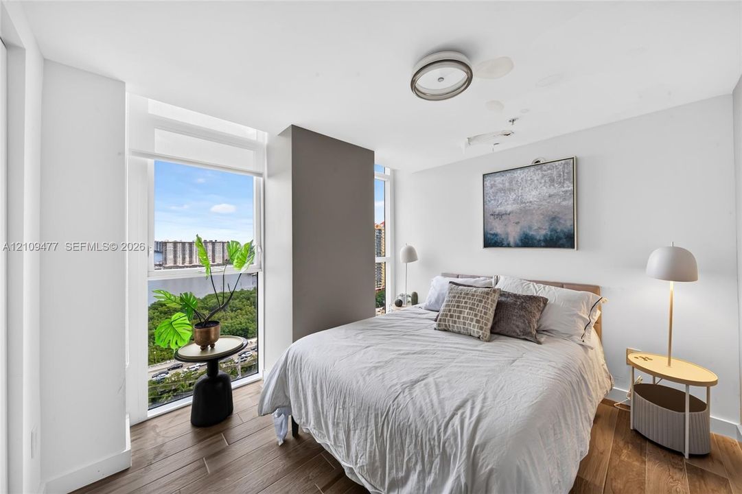 Open-concept interior featuring large-format tile flooring, expansive floor-to-ceiling glass windows, linear pendant lighting, and a private balcony