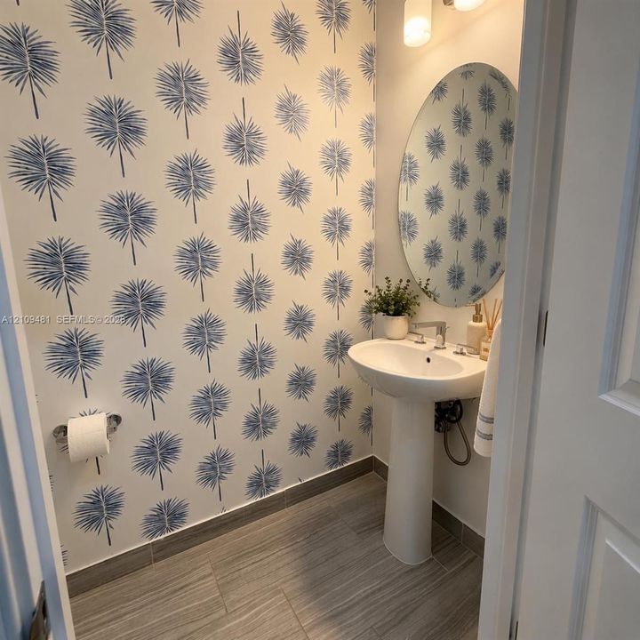 Interior hallway featuring grey-toned wood-finish tile flooring, recessed ceiling lighting, and crisp white-painted walls