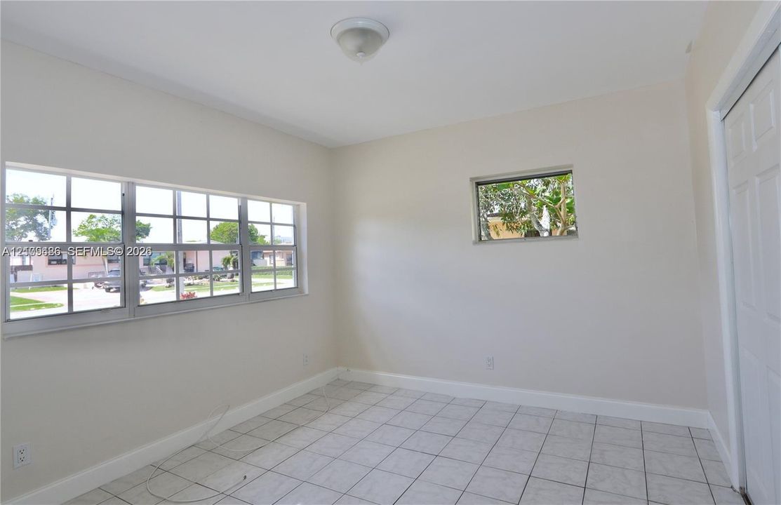 Room featuring neutral wall tones, ceramic tile flooring, multi-pane windows, and a flush-mount light fixture