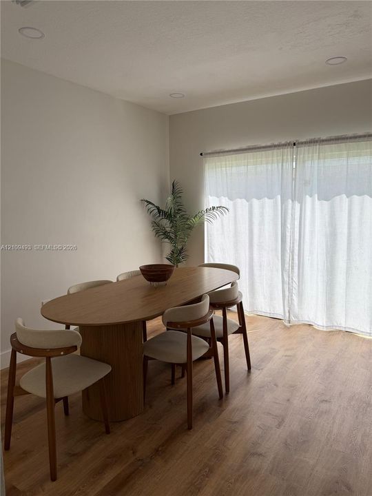 Wood-finish flooring, recessed lighting, and large sliding glass doors