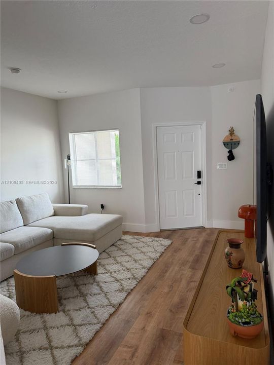 Interior space featuring wood-finish flooring, recessed lighting, and a six-panel entry door