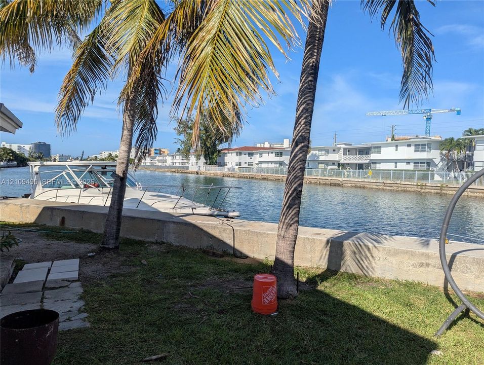 Waterfront property featuring a concrete seawall and palm trees