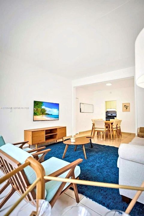 Open-concept interior featuring neutral wall tones, large-format tile flooring, and recessed ceiling lighting