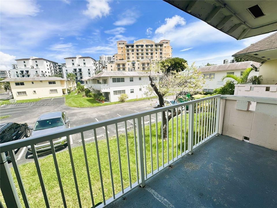 Private balcony featuring white metal railings and painted concrete flooring