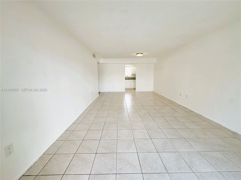 Open-concept area featuring neutral wall finishes, tile flooring, and a flush-mount ceiling light fixture